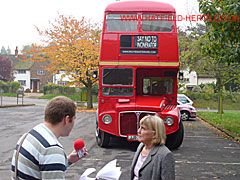 Cathy Roe being interviewed for radio in front of one of the Routemaster buses that brought demonstrators