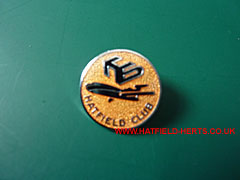 Circular Hawker Siddeley Hatfield Club pin badge - black text against orange background