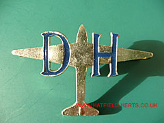 DH white metal with blue lettering badge