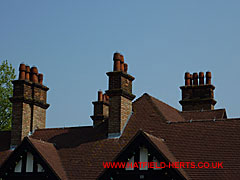 Red tile roof, brick chimneys and terracotta pots of Kennelwood House