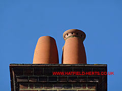 brick stack with two beehive-style orange colour clay  pots visible, one capped the other without