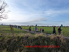 Tail of the march coming across the fields at the end of the footpath
