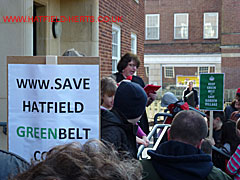 Councillor Perkins addressing the crowd, a couple of the placards visible